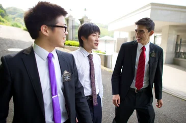 Two missionaries walking down a street.