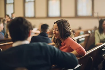 A family sitting in a church pew during a service.